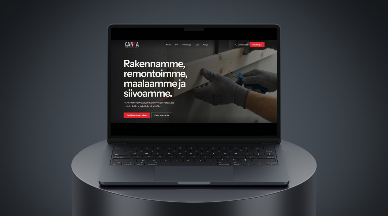 Kanfa construction website displayed on a dark laptop on a circular black plinth