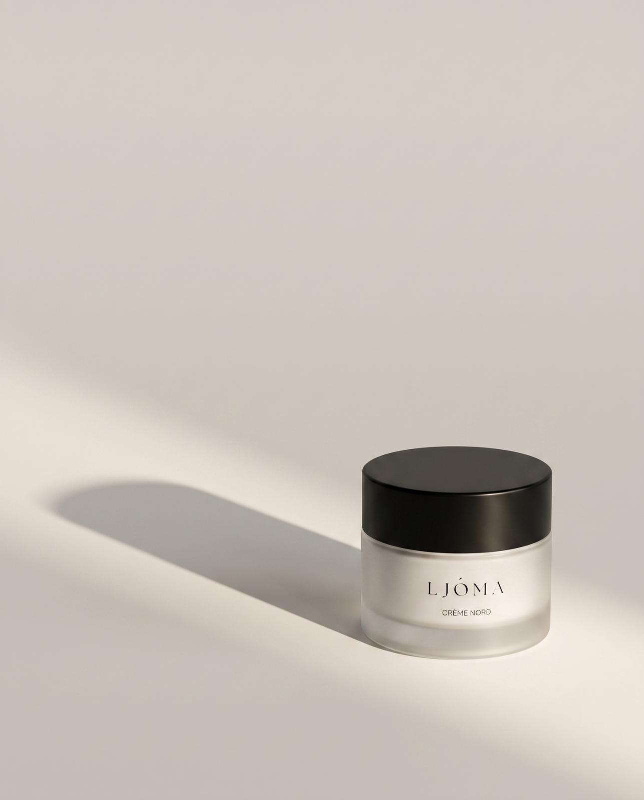 Ljóma Crème Nord jar casting a long shadow on a pale surface